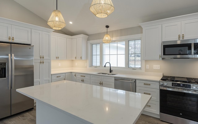 kitchen with dark wood-style flooring, appliances with stainless steel finishes, a sink, white cabinetry, and lofted ceiling