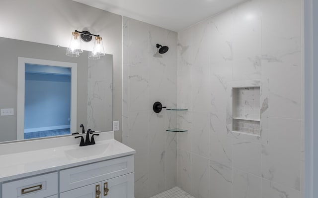 full bathroom with a tile shower and vanity