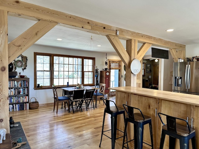 kitchen featuring recessed lighting, wood counters, stainless steel fridge with ice dispenser, and light wood-type flooring