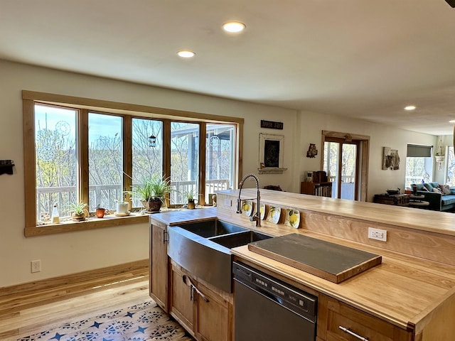 kitchen featuring dishwasher, a sink, light wood finished floors, open floor plan, and recessed lighting