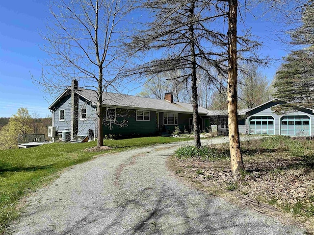 single story home with a front lawn, driveway, and a chimney