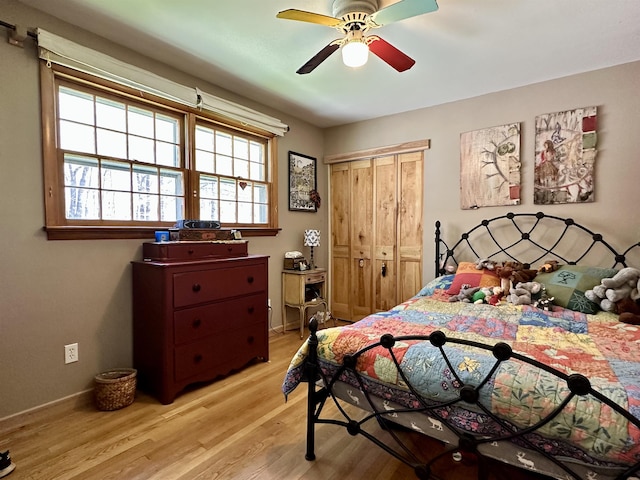 bedroom with a closet, a ceiling fan, light wood finished floors, and baseboards