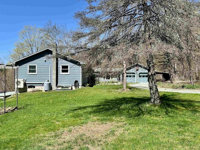 view of yard featuring a garage and an outbuilding