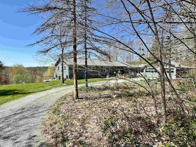 view of front of house with a front lawn and gravel driveway