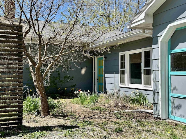 view of side of property featuring a shingled roof