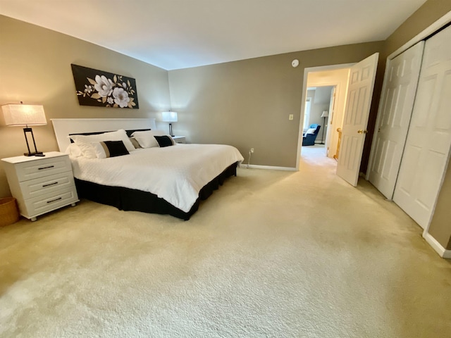 bedroom with baseboards, light colored carpet, and a closet