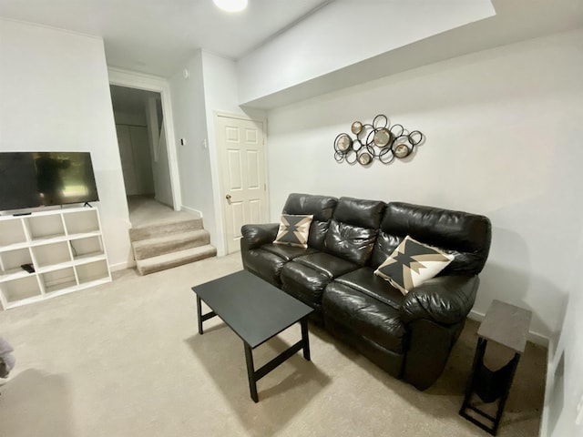 carpeted living area featuring stairway