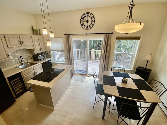 kitchen featuring tasteful backsplash, dishwasher, a sink, light countertops, and stainless steel microwave