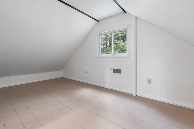 bonus room with baseboards, lofted ceiling, and visible vents