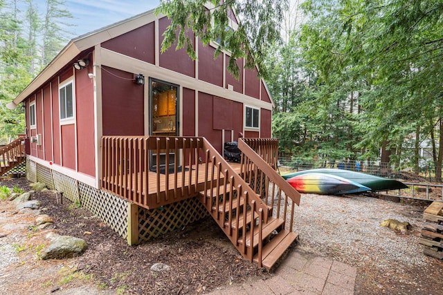 rear view of property featuring a deck, stairway, and crawl space