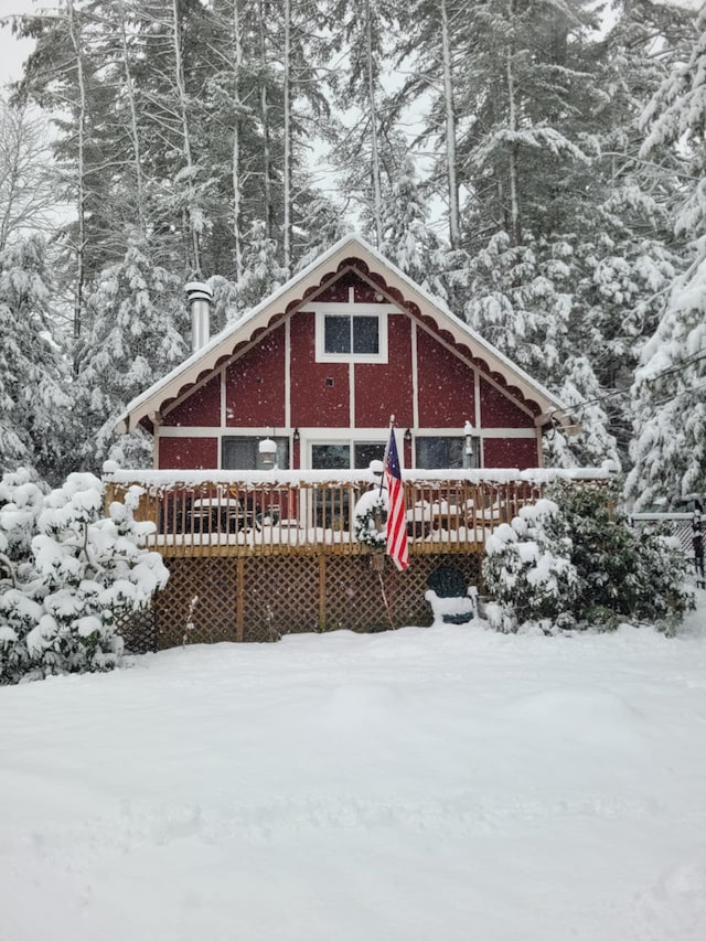 snow covered rear of property with a wooden deck