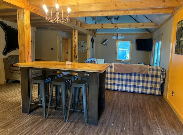 interior space with an inviting chandelier, pendant lighting, wood finished floors, beam ceiling, and baseboards