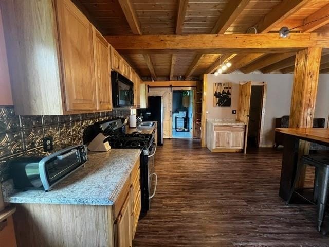 kitchen with stainless steel range with gas stovetop, beamed ceiling, black microwave, and dark wood finished floors