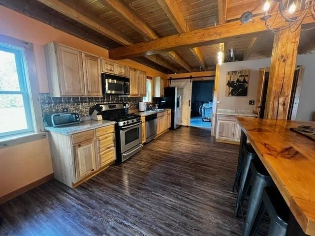 kitchen featuring appliances with stainless steel finishes, dark wood finished floors, a barn door, beamed ceiling, and butcher block counters