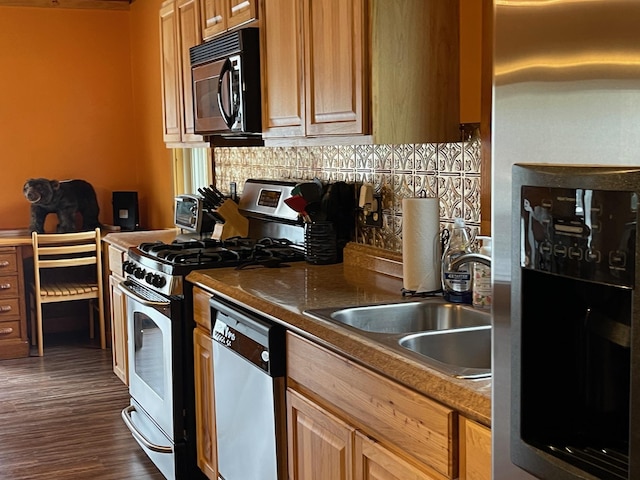 kitchen with decorative backsplash, dark countertops, a sink, dark wood-style floors, and stainless steel appliances