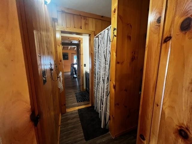 hallway with wood finished floors and wooden walls