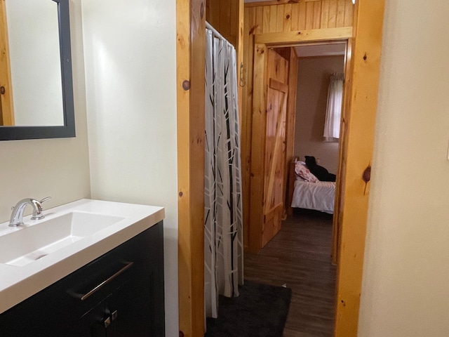 full bathroom featuring a shower with shower curtain, wood finished floors, and vanity
