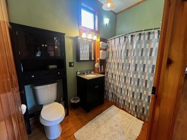 bathroom with vanity, crown molding, wood finished floors, toilet, and a shower with shower curtain