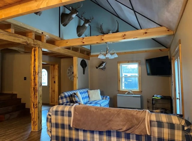 living room featuring lofted ceiling with beams, stairs, wood finished floors, and a notable chandelier