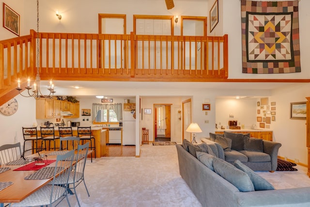 16 Riverfront Dr Unit 292, Woodstock, NH 03262 - living area featuring light colored carpet, a towering ceiling, and an inviting chandelier