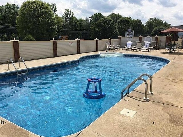 pool with fence and a patio area