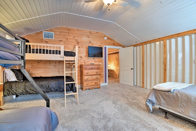 bedroom featuring wooden walls, ceiling fan, carpet floors, lofted ceiling, and visible vents
