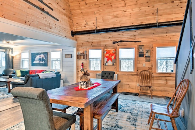 dining space with wooden walls and a towering ceiling