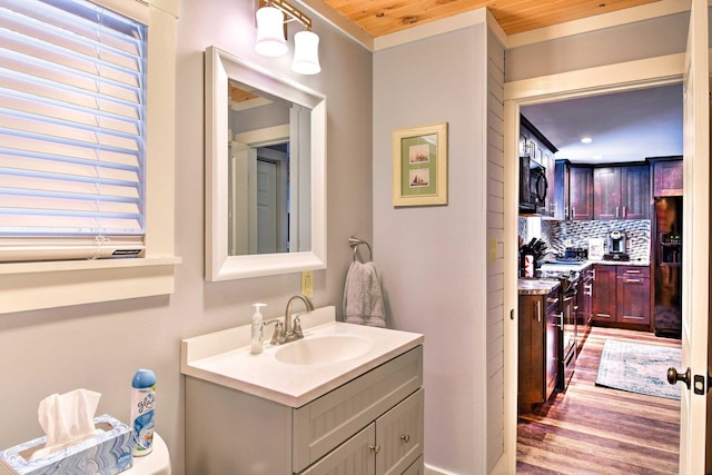 bathroom with vanity, wooden ceiling, wood finished floors, tasteful backsplash, and ornamental molding