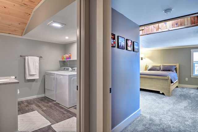 clothes washing area featuring laundry area, baseboards, washing machine and dryer, and wood ceiling