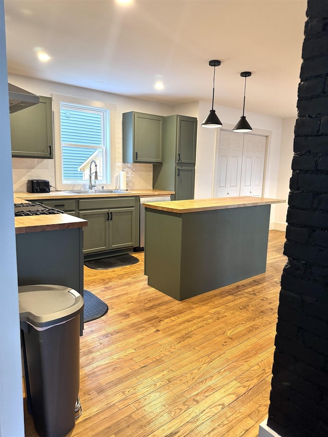 kitchen featuring a sink, decorative backsplash, and wooden counters