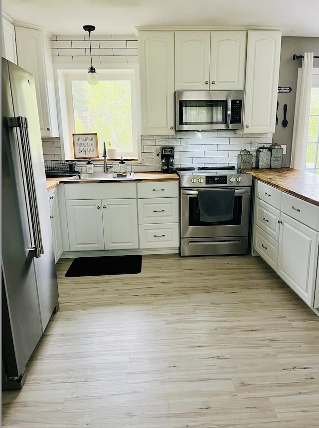 1 Boyd Rd, Londonderry, NH 03053 - kitchen featuring pendant lighting, wooden counters, a sink, backsplash, and stainless steel appliances
