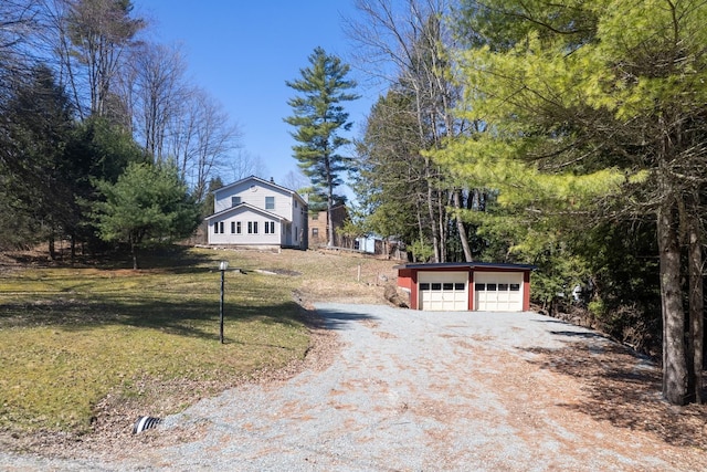 exterior space featuring a lawn, a garage, an outdoor structure, and dirt driveway