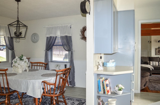 dining area with wainscoting, wood finished floors, and a notable chandelier