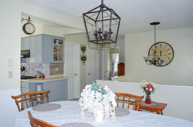 dining space with a wainscoted wall and a chandelier