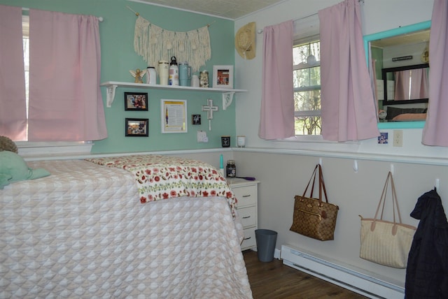 bedroom with a baseboard radiator and wood finished floors