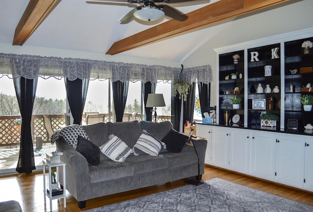 living area with a ceiling fan, lofted ceiling with beams, plenty of natural light, and wood finished floors