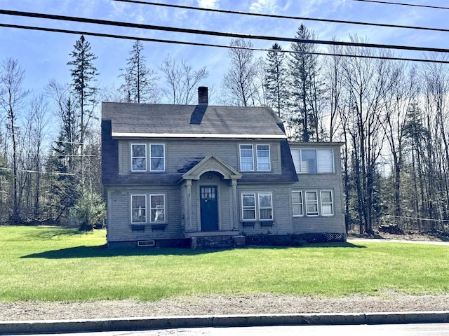 view of front of home featuring a chimney and a front yard