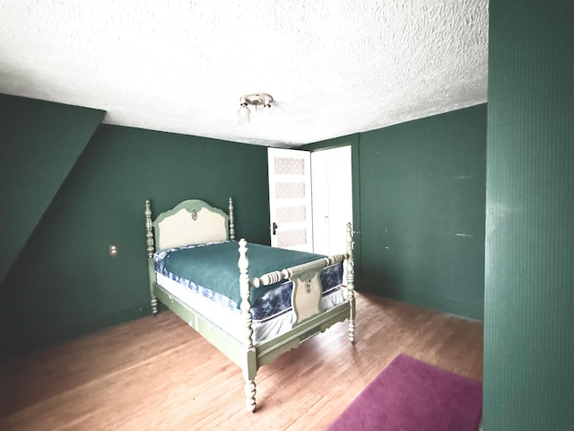 bedroom featuring a textured ceiling and wood finished floors