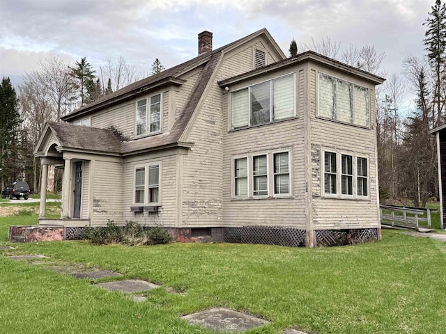 view of side of property with a yard and a chimney