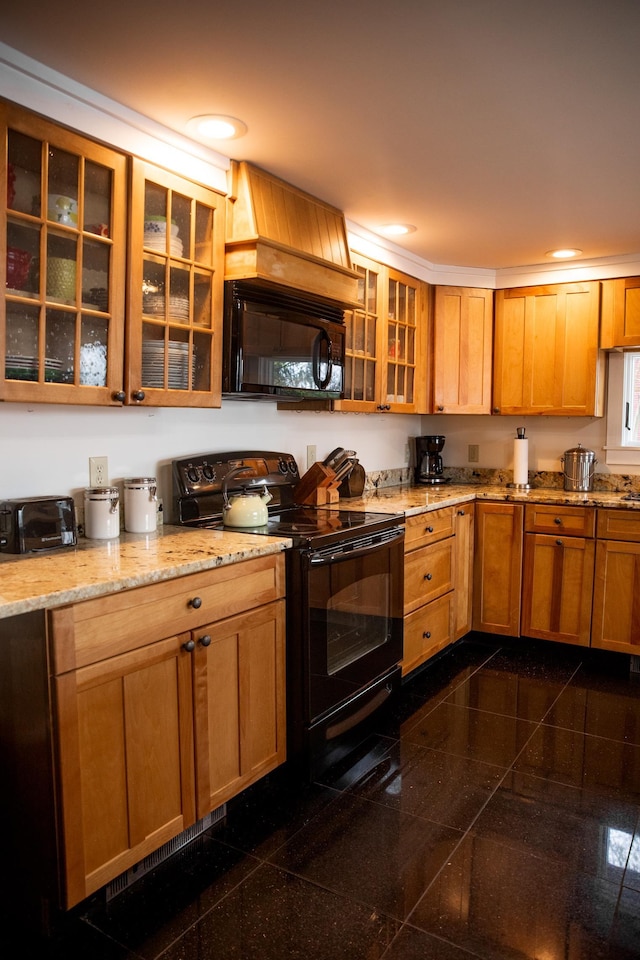 kitchen featuring light stone countertops, granite finish floor, recessed lighting, glass insert cabinets, and black appliances