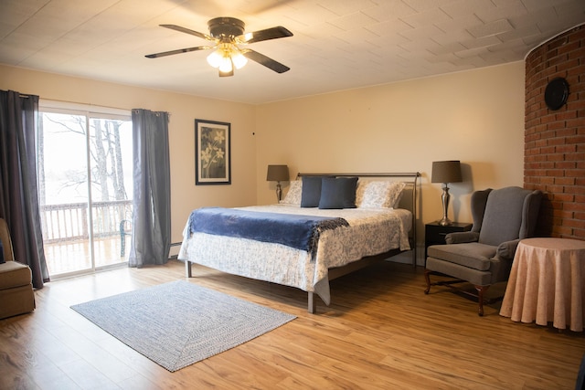 bedroom with ceiling fan, access to exterior, a baseboard radiator, and light wood-style floors