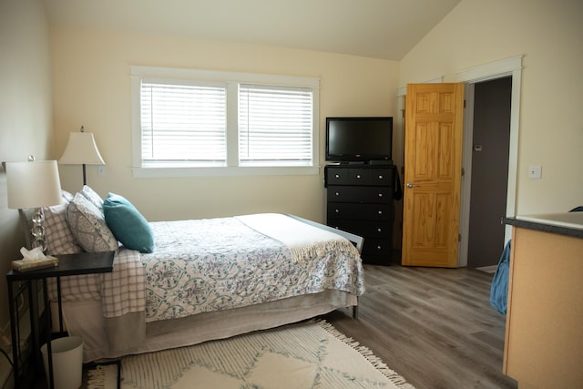 bedroom featuring wood finished floors and lofted ceiling