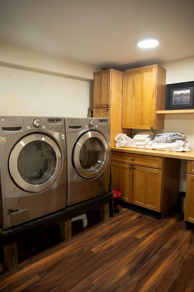 clothes washing area featuring dark wood-type flooring, cabinet space, and separate washer and dryer
