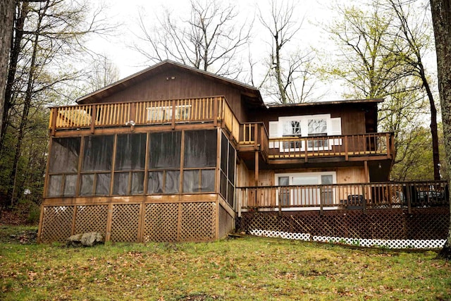 back of house featuring a lawn, a sunroom, a deck, and a balcony