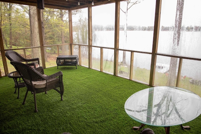 sunroom featuring a water view
