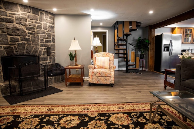 sitting room featuring baseboards, recessed lighting, stairs, and wood finished floors