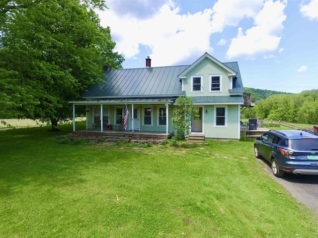 1907 River Rd, Moretown, VT 05602 - view of front facade featuring a porch, a front yard, a chimney, a standing seam roof, and metal roof