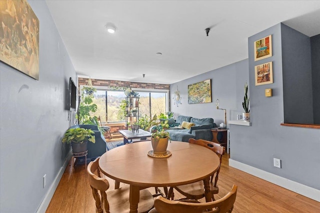 dining space with baseboards and wood finished floors