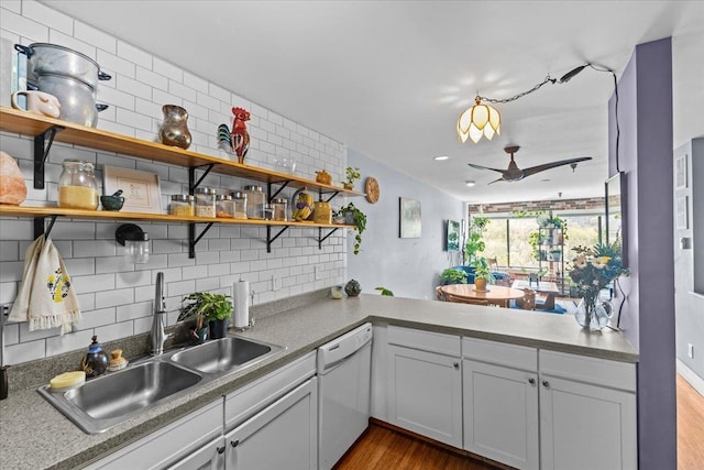 kitchen with ceiling fan, open shelves, wood finished floors, dishwasher, and a sink