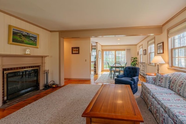 living area featuring crown molding, baseboards, a fireplace with flush hearth, and wood finished floors